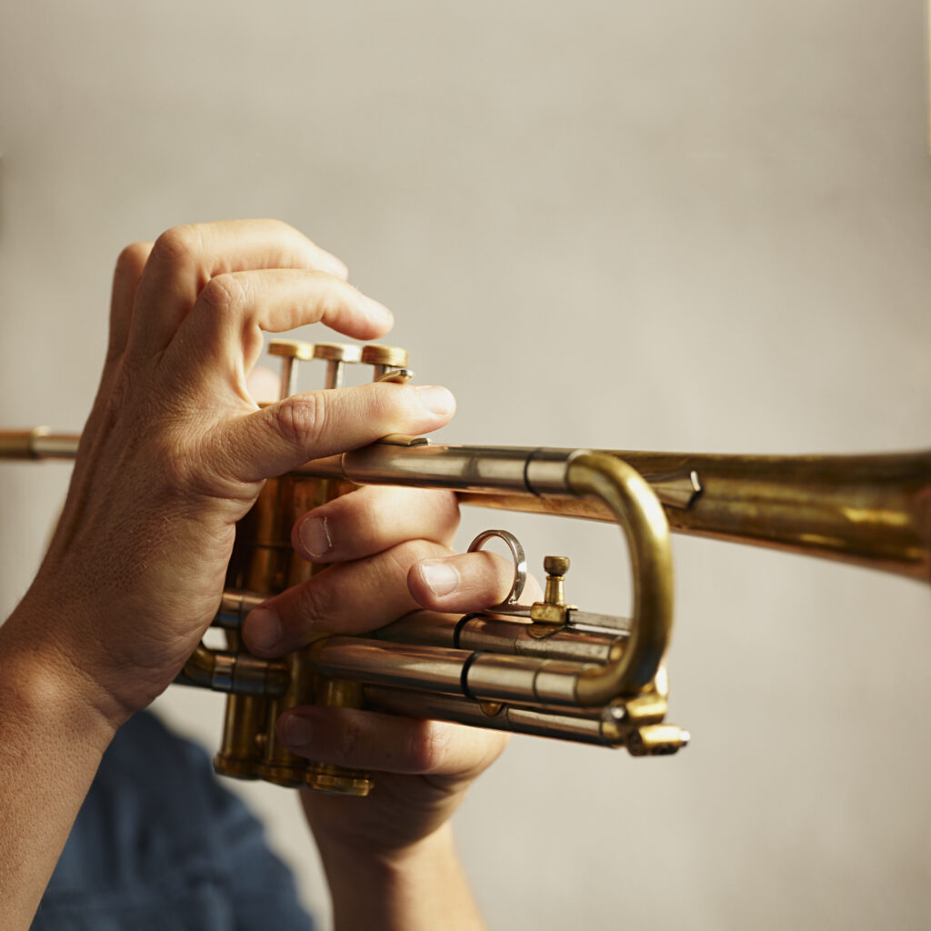 Hands playing a trumpet