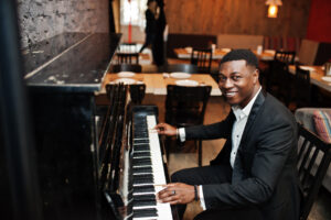 man playing piano keys in an online piano lesson music teacher