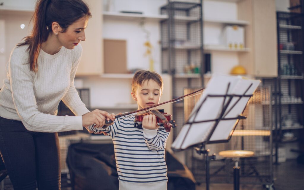 Young boy learning to play a violin