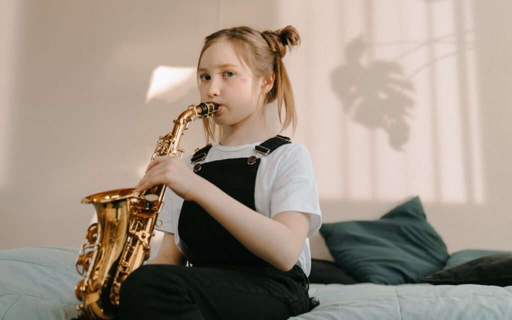 girl playing saxophone during saxophone lessons