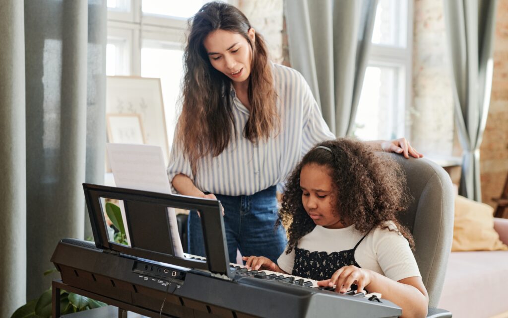 Little girl having piano lessons