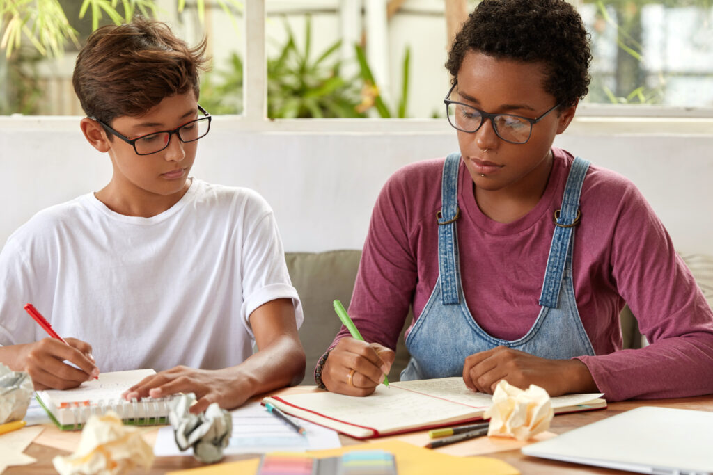 Students writing notes at a desk